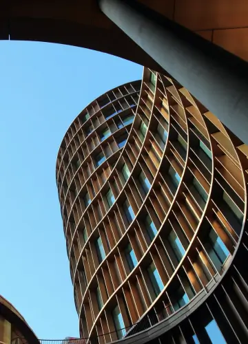 A modern building featuring a distinctive curved wooden structure, showcasing innovative architectural design.