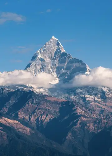 A majestic mountain with a snow-covered peak, showcasing the beauty of nature against a clear blue sky.